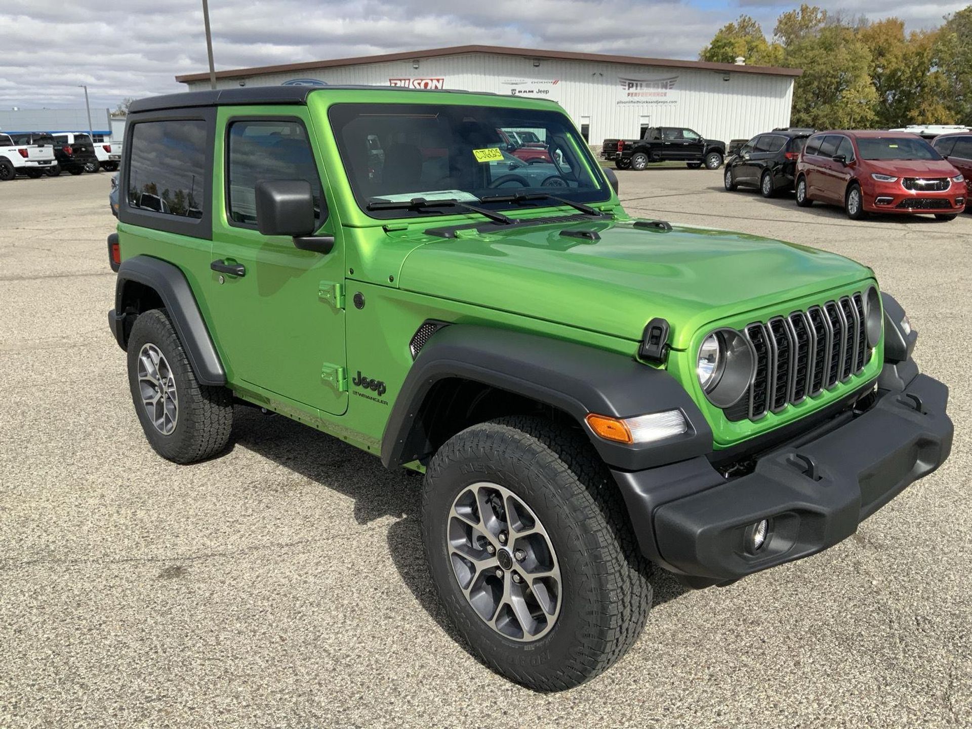 Front quarter view of a Mojito green Jeep Wrangler 2-Door showing the seven-slot grille, round LED headlights, fender flares and alloy wheels